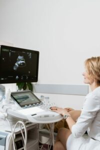 Woman using an ultrasound machine. 